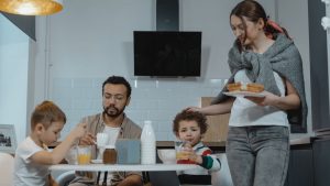 A family shares a joyful breakfast in a cozy kitchen setting, capturing a warm morning moment.