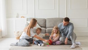 Family bonding time on the carpet in a cozy living room setting.